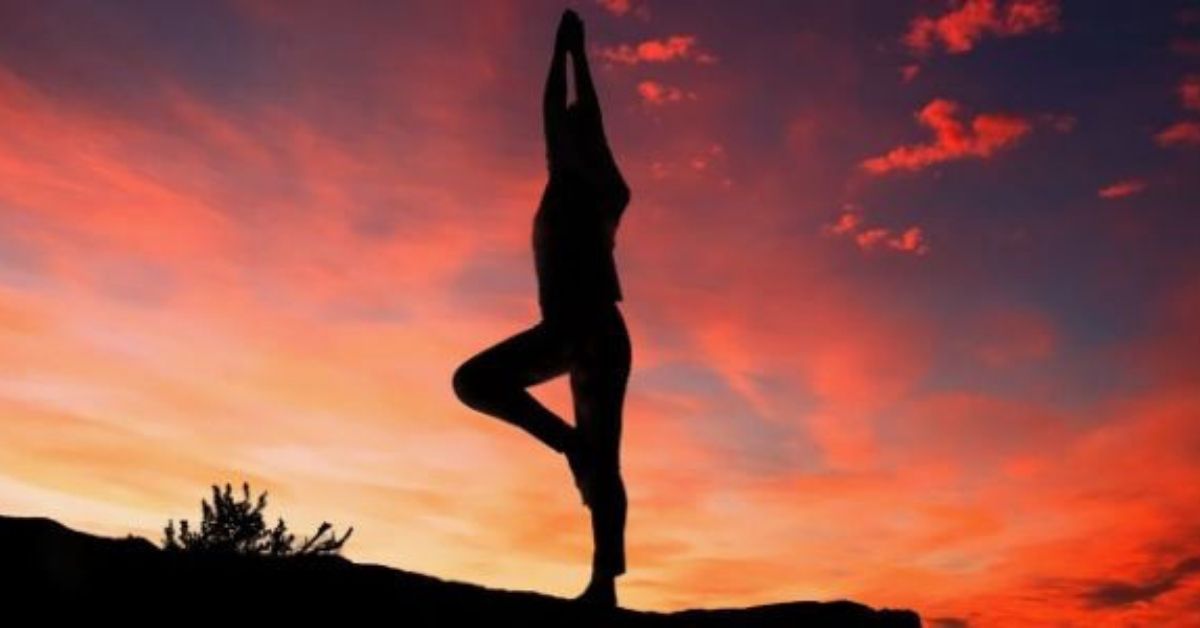 Person doing yoga in front of sunset