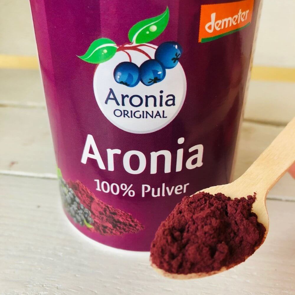 aronia original berry powder on wooden spoon